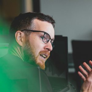 man in green shirt wearing black framed eyeglasses